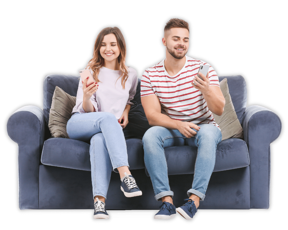 donna e uomo seduti sul divano che guardano il cellulare e sorridono